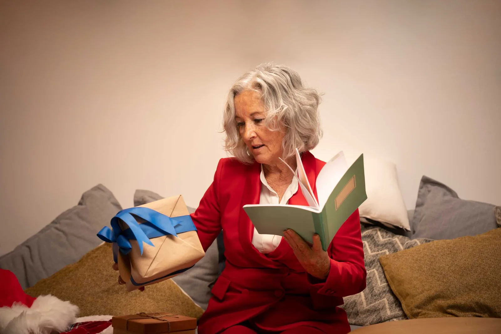 Mulher sênior segurando um presente e um caderno, simbolizando autocuidado e organização emocional no Natal.
