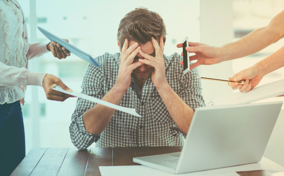 Homem estressado com muitas demandas ao mesmo tempo.