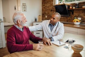 Médico conversando com paciente idoso de forma empática, simbolizando acolhimento e cuidado com a saúde mental.