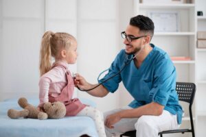 Pediatra examinando criança com estetoscópio durante consulta infantil.