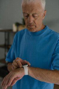 Idoso monitorando a saúde através de smartwatch, observando sinais vitais.